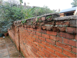 Red brick wall, crumbling at the top